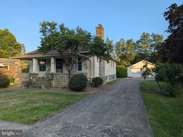 a front view of a house with yard and green space