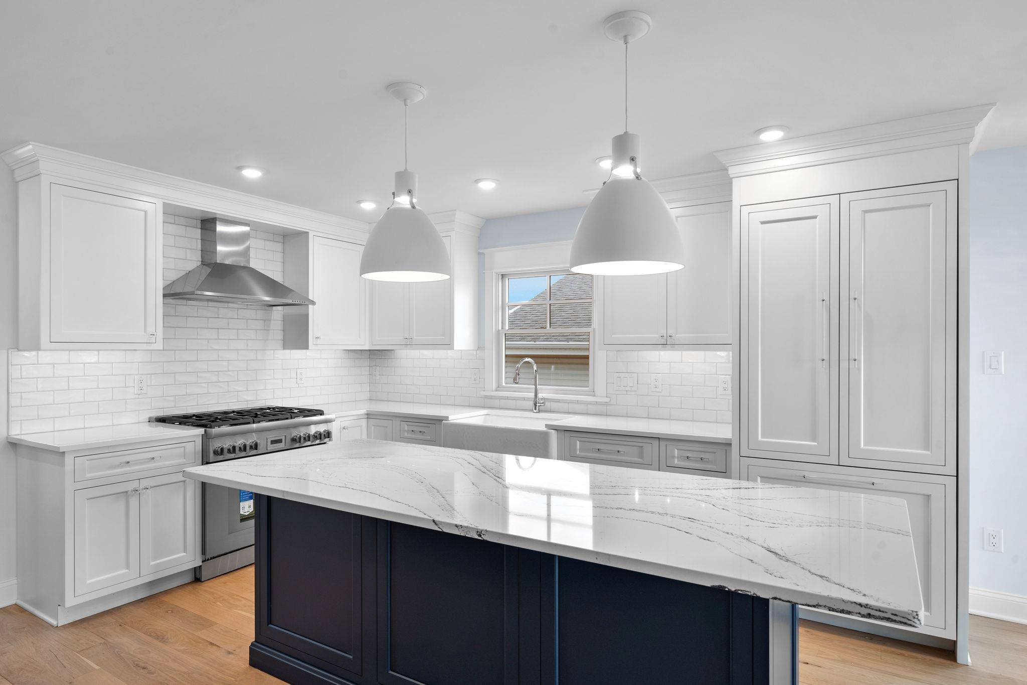 249 35th Street, Unit EAST SIDE Avalon, NJ 08202 - Photo 5 of 45 a kitchen with kitchen island granite countertop a sink a counter space appliances and cabinets
