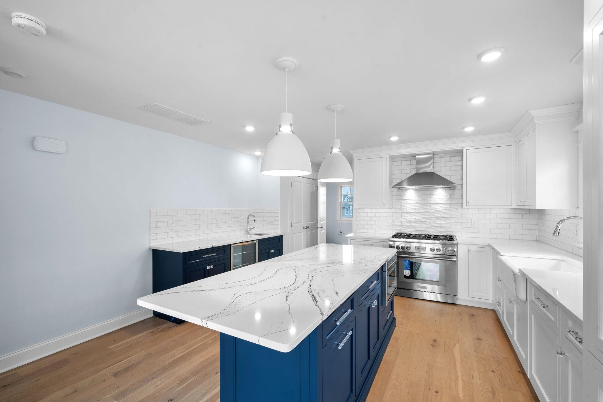 249 35th Street, Unit EAST SIDE Avalon, NJ 08202 - Photo 10 of 45 a large kitchen with stainless steel appliances a large counter top a stove a sink dishwasher and a refrigerator