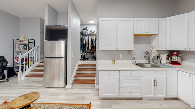 630 1100 West Provo, UT 84601 - Photo 10 of 64 White cabinetry with satin nickel hardware and a stainless steel sink, complemented by light-toned countertops