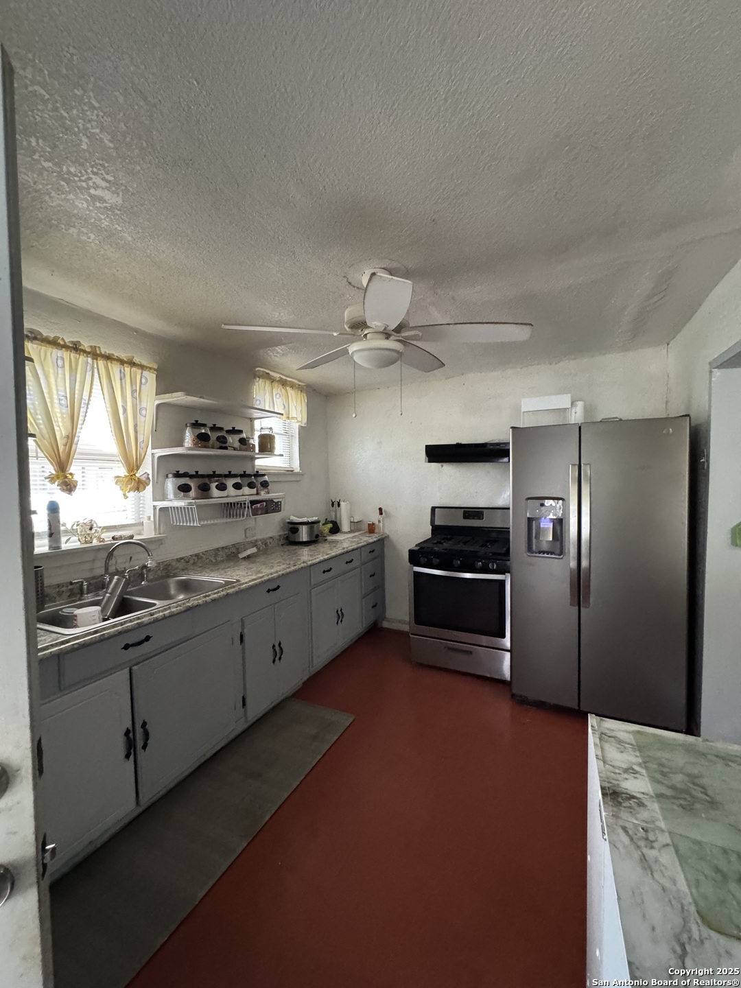 416 16th Street Hondo, TX 78861 - Photo 5 of 6 a kitchen with granite countertop a refrigerator and a stove top oven
