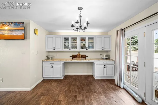 a large kitchen with stainless steel appliances a stove and wooden floor