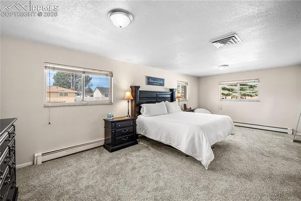a bedroom with a large bed and a chandelier