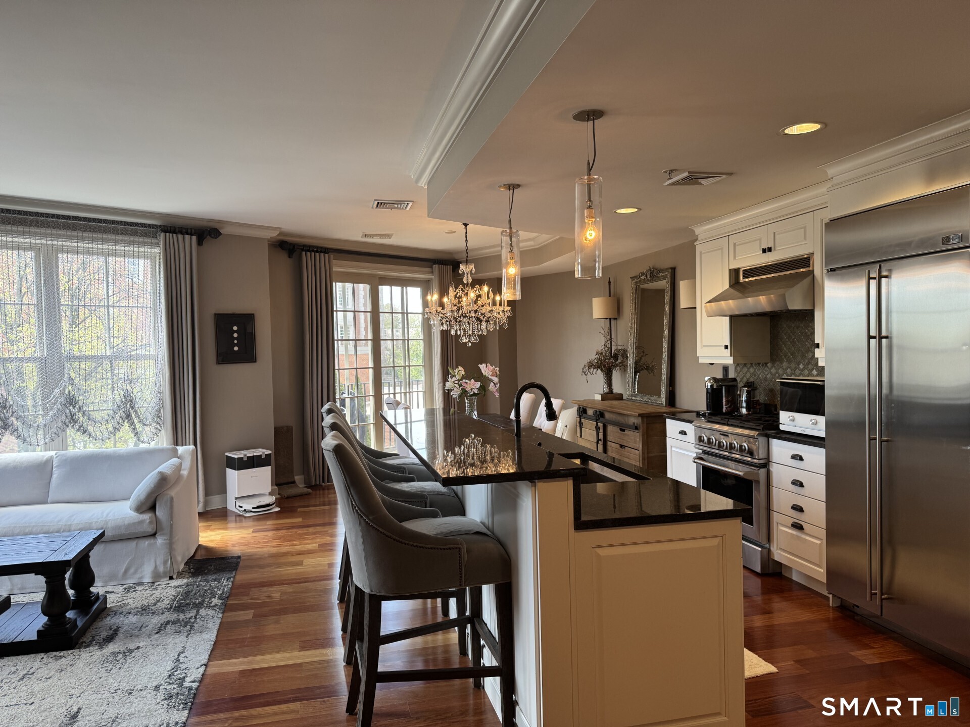 85 Memorial Road, Unit 201 West Hartford, CT 06107 - Photo 13 of 36 a kitchen with stainless steel appliances kitchen island granite countertop a refrigerator a stove a dining table and chairs with wooden floor