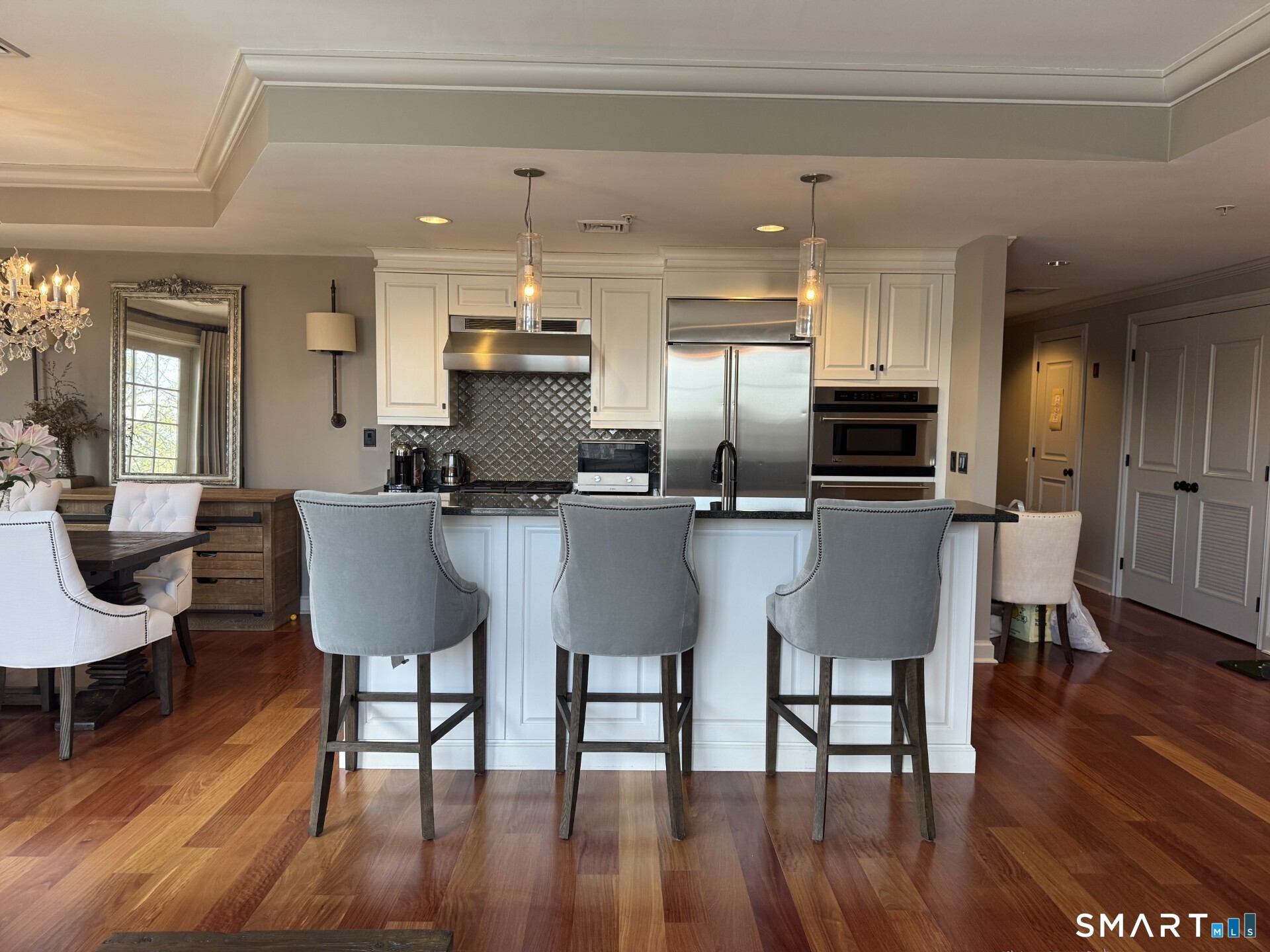 85 Memorial Road, Unit 201 West Hartford, CT 06107 - Photo 14 of 36 a kitchen with stainless steel appliances kitchen island granite countertop a dining table chairs and a refrigerator