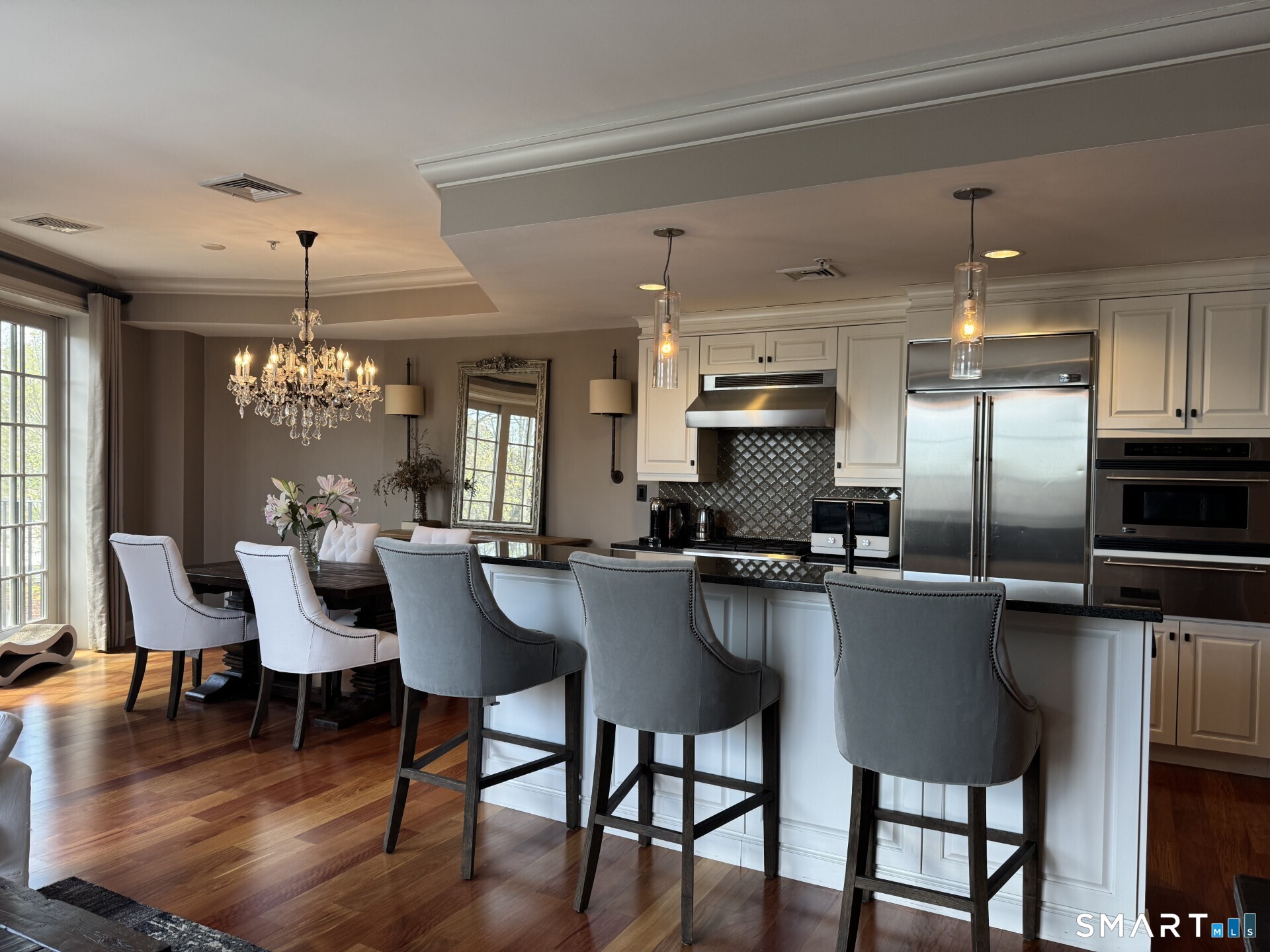 85 Memorial Road, Unit 201 West Hartford, CT 06107 - Photo 15 of 36 a kitchen with stainless steel appliances kitchen island granite countertop a table chairs and a refrigerator
