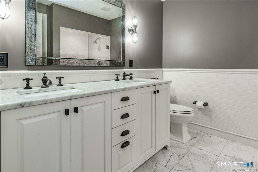 85 Memorial Road, Unit 201 West Hartford, CT 06107 - Photo 24 of 36 a bathroom with a sink a toilet and a mirror