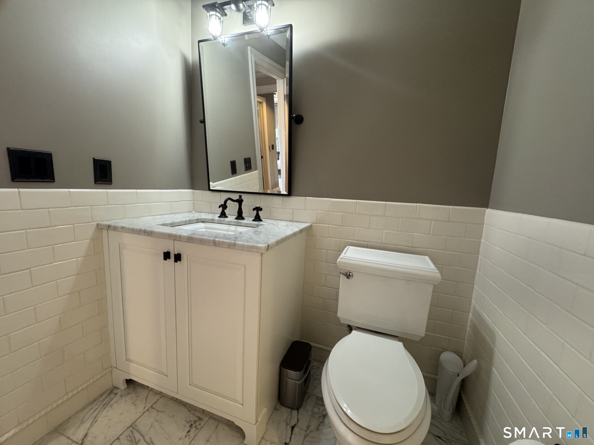 85 Memorial Road, Unit 201 West Hartford, CT 06107 - Photo 30 of 36 a bathroom with a toilet sink and mirror