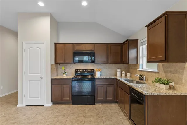 a kitchen with stainless steel appliances granite countertop a stove a sink and a refrigerator