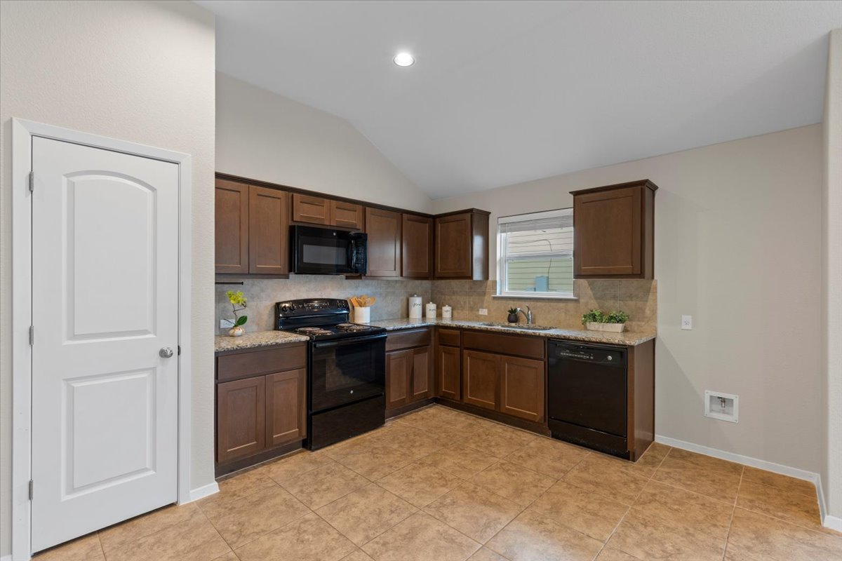 123 Saranac Drive Elgin, TX 78621 - Photo 8 of 26 a kitchen with stainless steel appliances granite countertop a stove a sink and a refrigerator