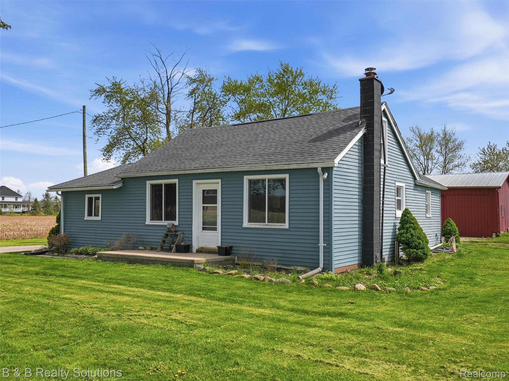 21900 Bordman Road Armada, MI 48005 - Photo 26 of 55 Back of property with a chimney, a yard, and a shingled roof
