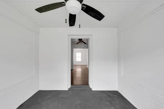 an empty room with closet and windows