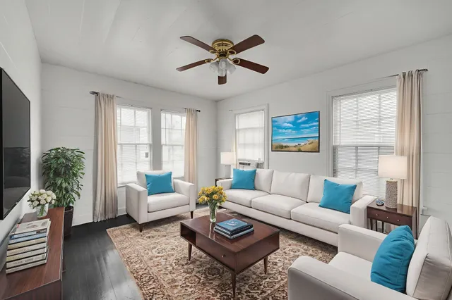 a living room with furniture and a large window with wooden floor