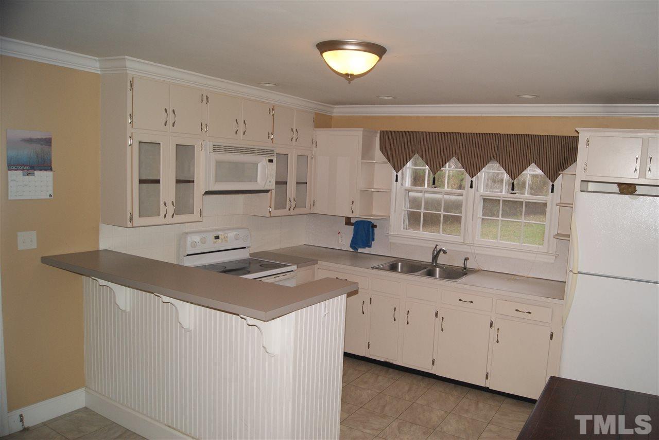 9716 Sauls Road Raleigh, NC 27603 - Photo 10 of 23 a kitchen with stainless steel appliances granite countertop a sink stove and cabinets