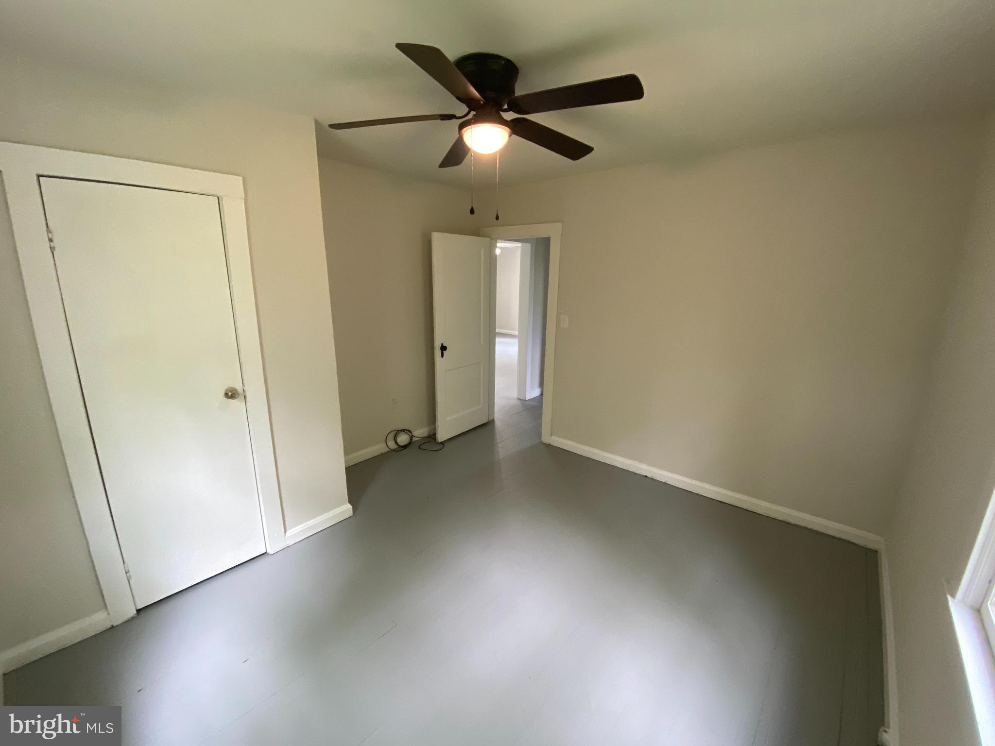 9067 St Anthonys Road King George, VA 22485 - Photo 16 of 24 an empty room with wooden floor fan and windows