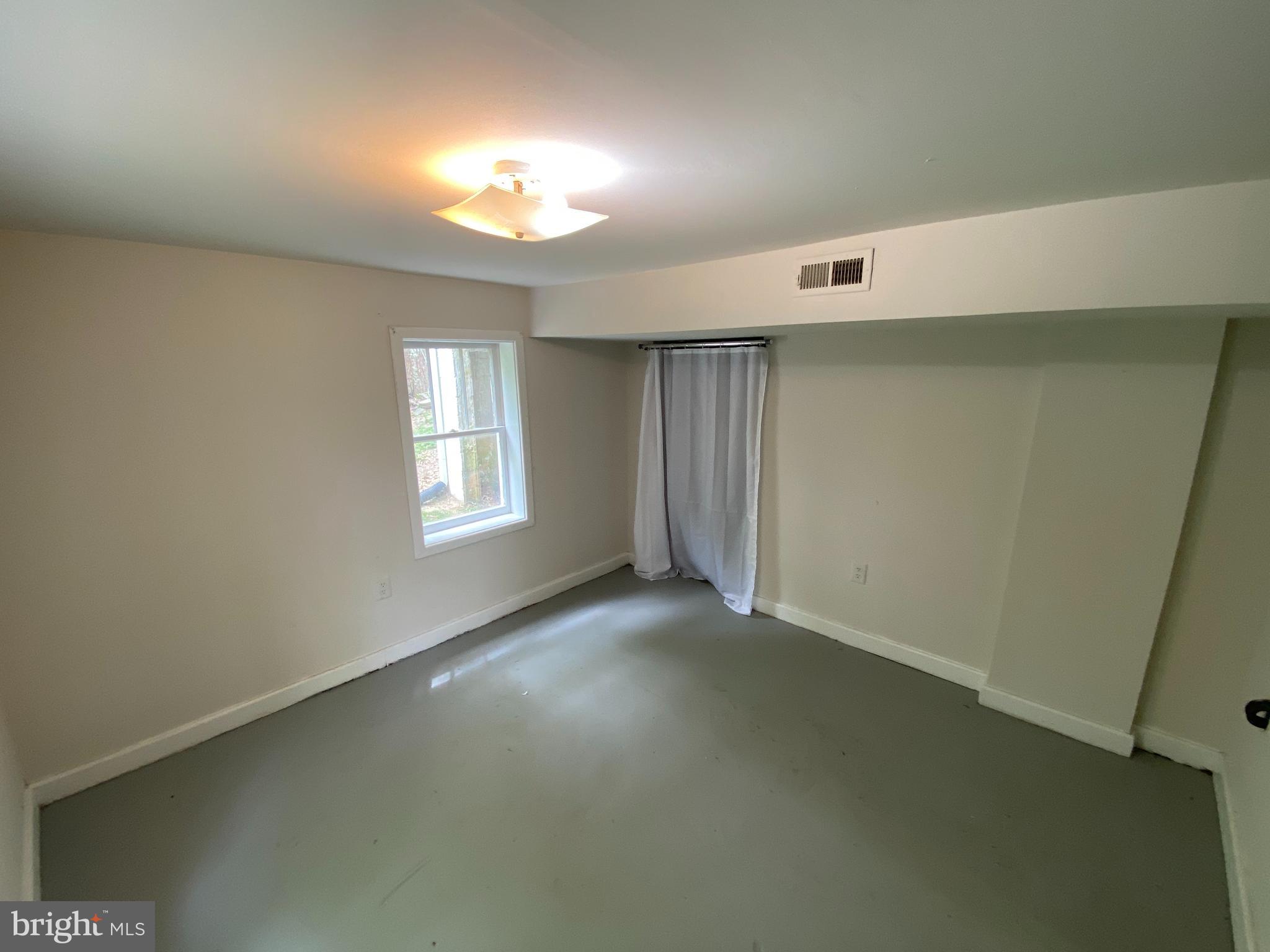 9067 St Anthonys Road King George, VA 22485 - Photo 23 of 24 an empty room with a windows and fireplace