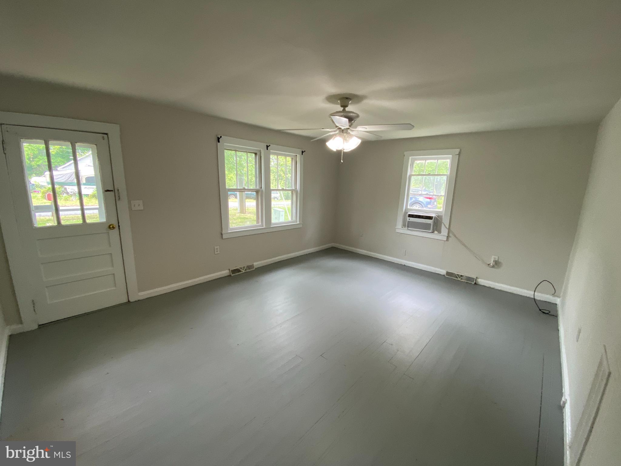 9067 St Anthonys Road King George, VA 22485 - Photo 3 of 24 an empty room with windows and fan