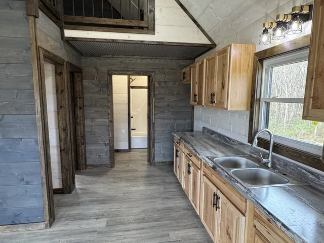 a large kitchen with a wooden floor and a sink