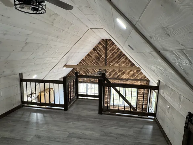 a view of an empty room with wooden floor and staircase