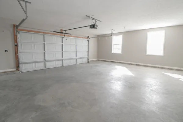 a view of an empty room with kitchen and a window