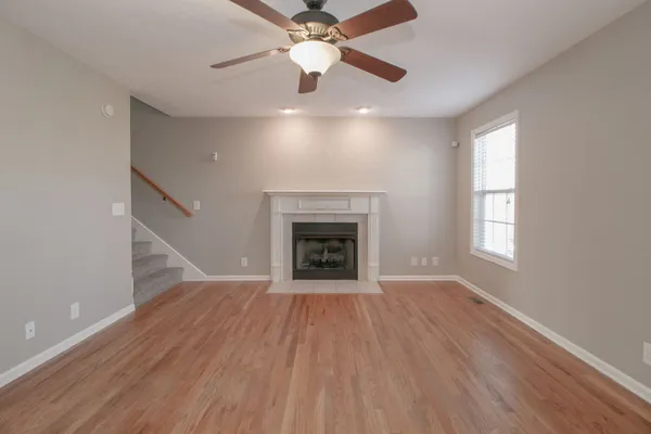 an empty room with a chandelier fan and a window
