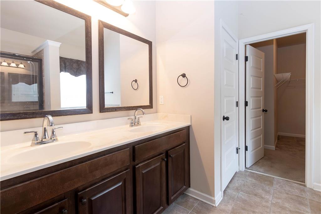 70 Sylvan Loop Fayetteville, GA 30214 - Photo 30 of 40 a bathroom with a double vanity sink a mirror and a shower