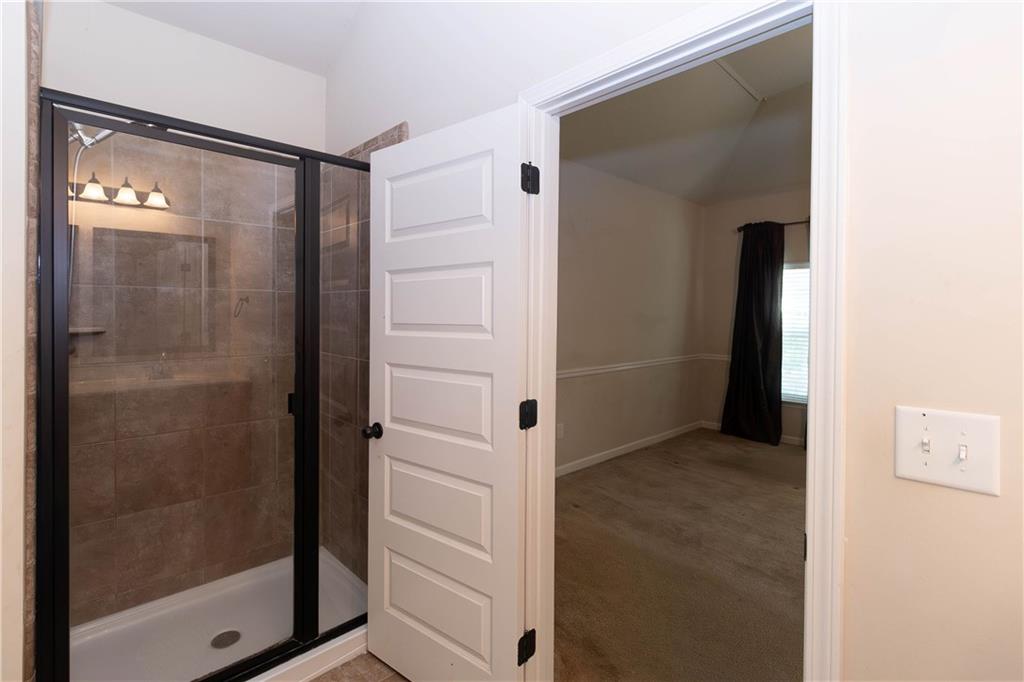 70 Sylvan Loop Fayetteville, GA 30214 - Photo 34 of 40 a bathroom with a glass shower door