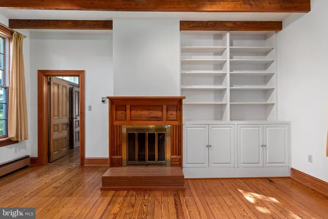 a view of an empty room with glass door and wooden floor