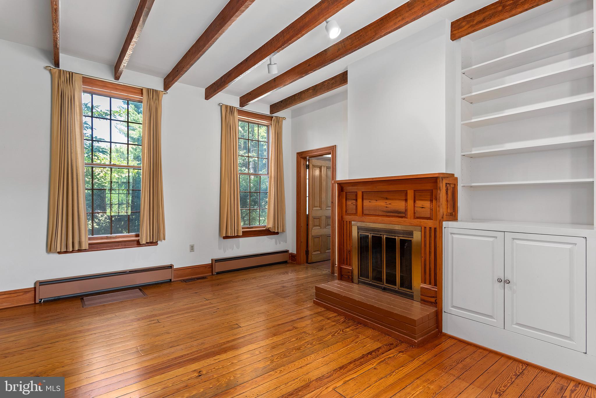 8293 Brices Mill Road Chestertown, MD 21620 - Photo 19 of 59 a view of an empty room with exposed radiator and fireplace