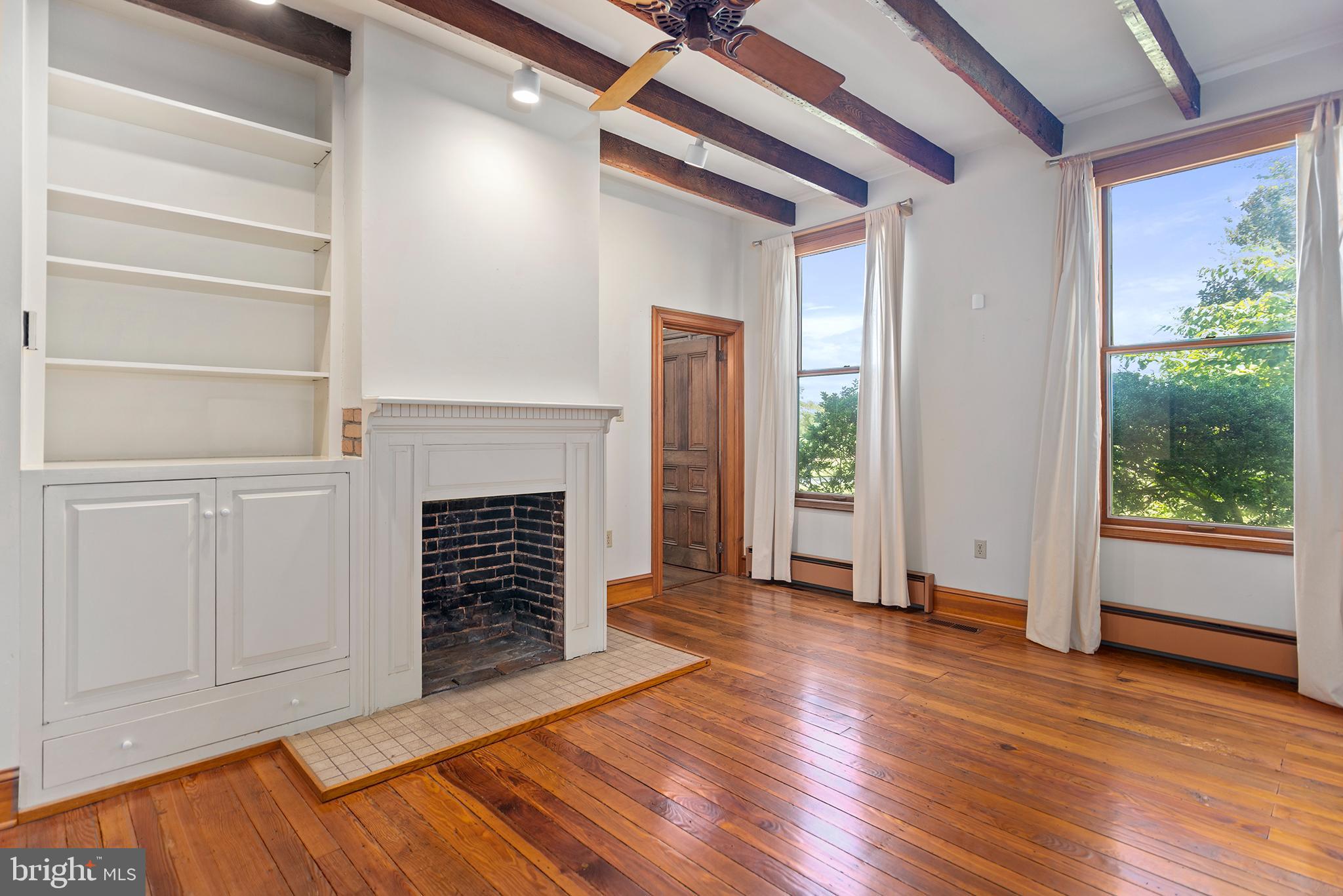 8293 Brices Mill Road Chestertown, MD 21620 - Photo 26 of 59 a view of an empty room with wooden floor fireplace and a window