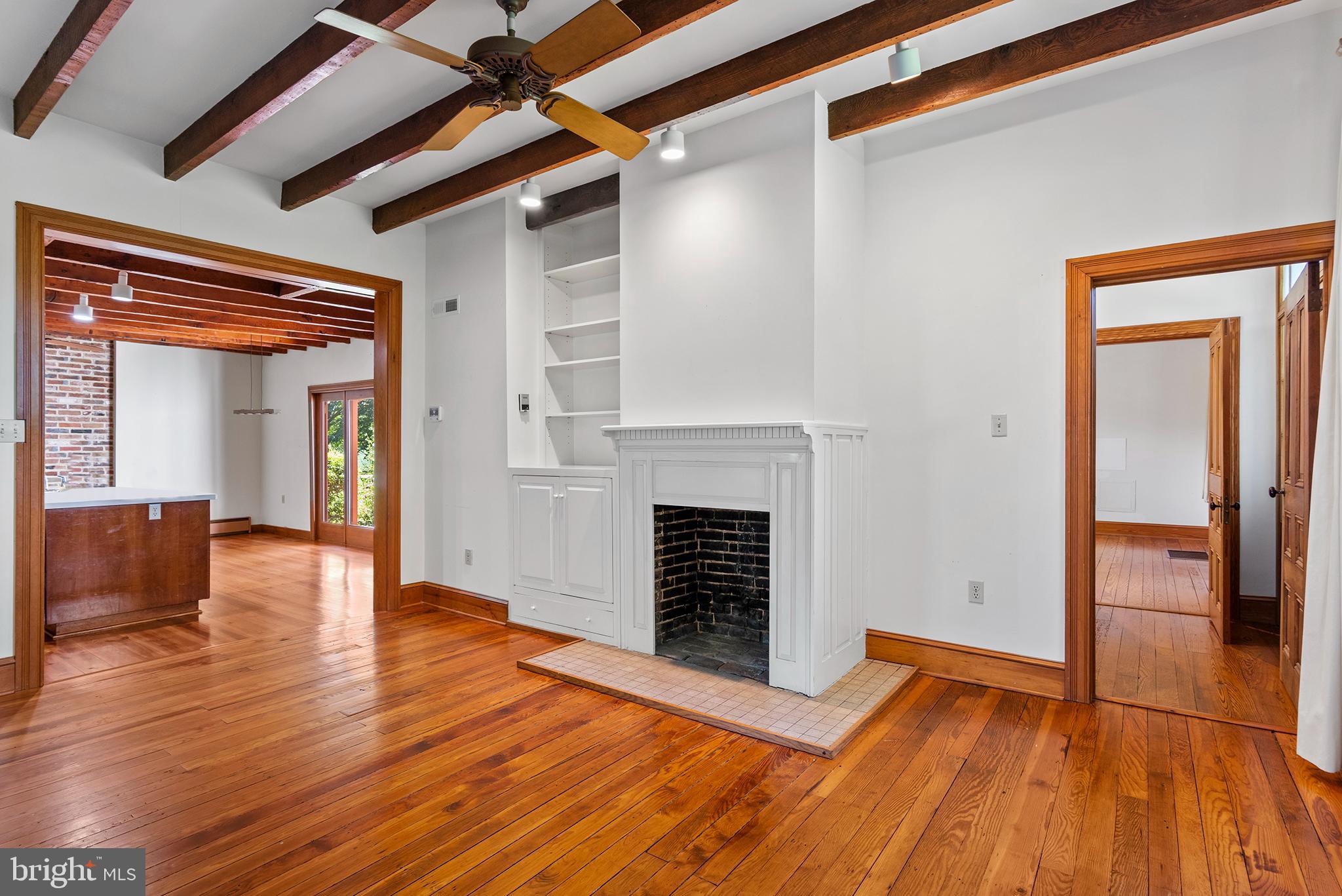 8293 Brices Mill Road Chestertown, MD 21620 - Photo 29 of 59 a view of an empty room with wooden floor fireplace and a window