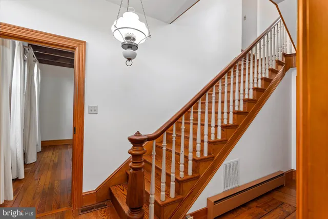 a view of a hallway with wooden floor and staircase
