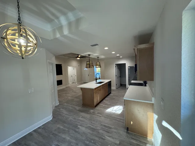 a large living room with a large window and chandelier