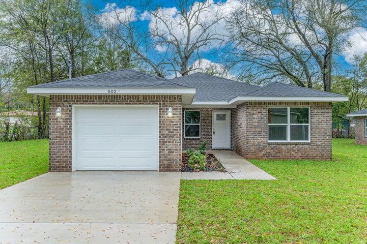 615 East Chestnut Avenue Crestview, FL 32539 - Photo 3 of 10 a front view of a house with a garden and yard