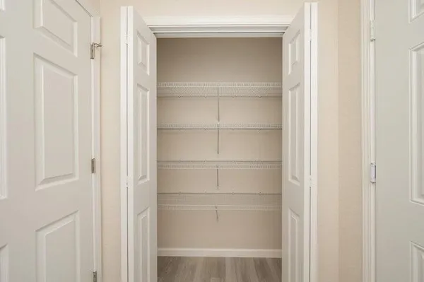 a view of walk in closet with empty racks