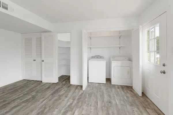 a view of empty room with wooden floor and cabinet