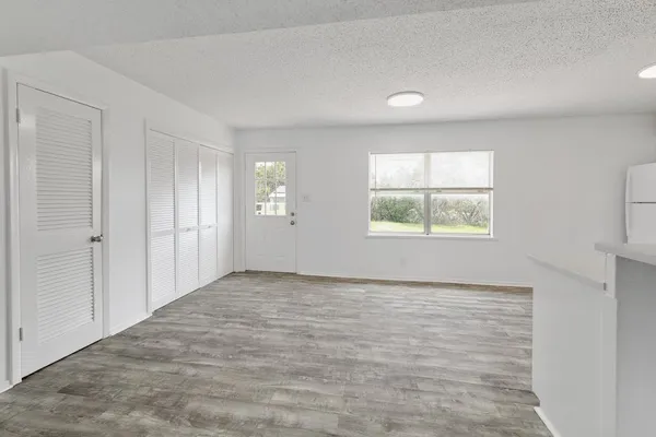 a view of a kitchen with an empty room and windows