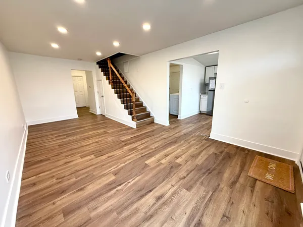 an empty room with wooden floor and stairs