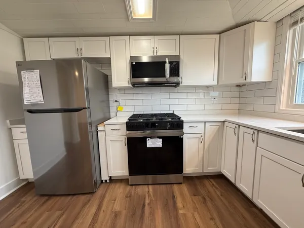 a kitchen with granite countertop a refrigerator stove and microwave