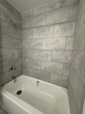a bathroom with a white bath tub and a shower