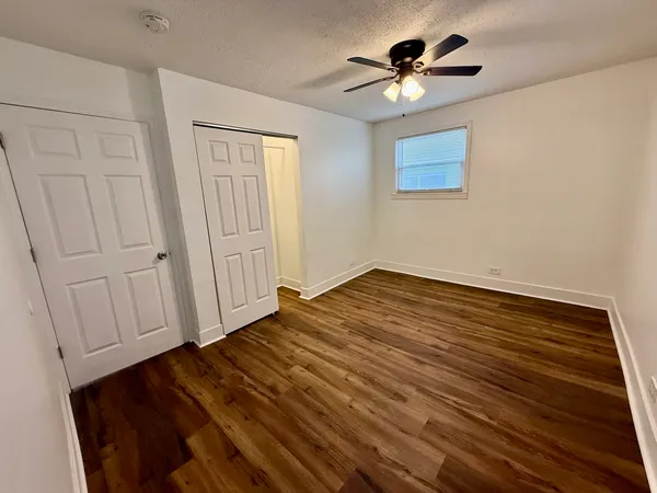 a view of empty room with wooden floor