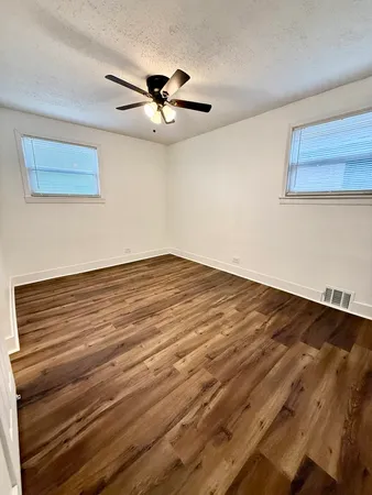a view of empty room with wooden floor