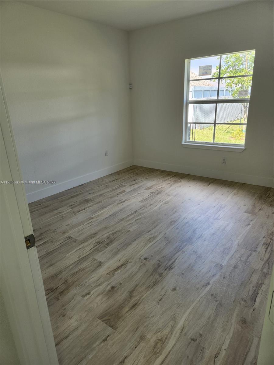 22065 Miami Avenue Miami, FL 33170 - Photo 13 of 27 an empty room with wooden floor and windows
