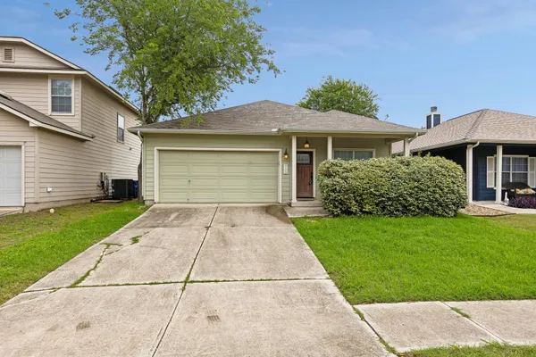 a front view of a house with a yard and a garage
