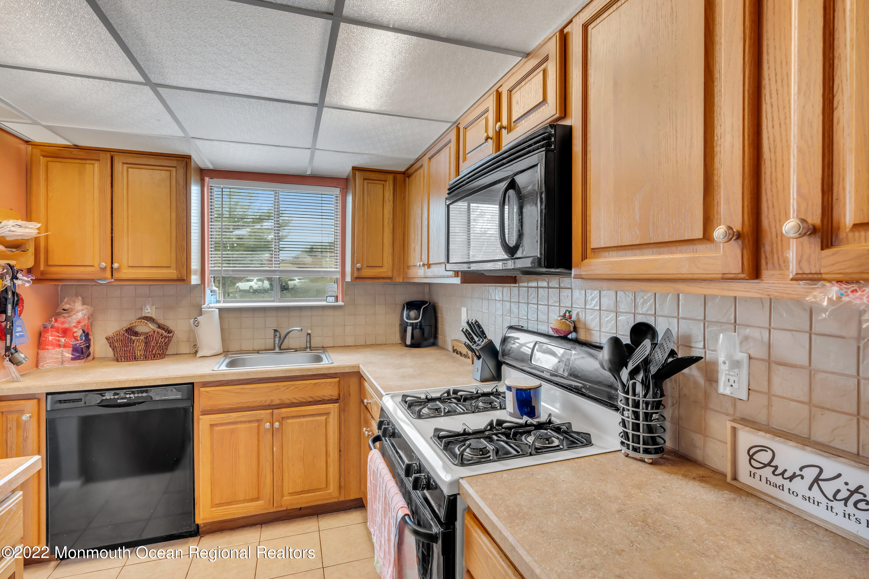 7 Jesse Drive Howell, NJ 07731 - Photo 20 of 25 a kitchen with stainless steel appliances a sink a stove a microwave cabinets and a window