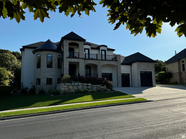 614 East High Lane Alpine, UT 84004 - Photo 4 of 75 French country inspired facade with stone siding, a balcony, driveway, and a front lawn