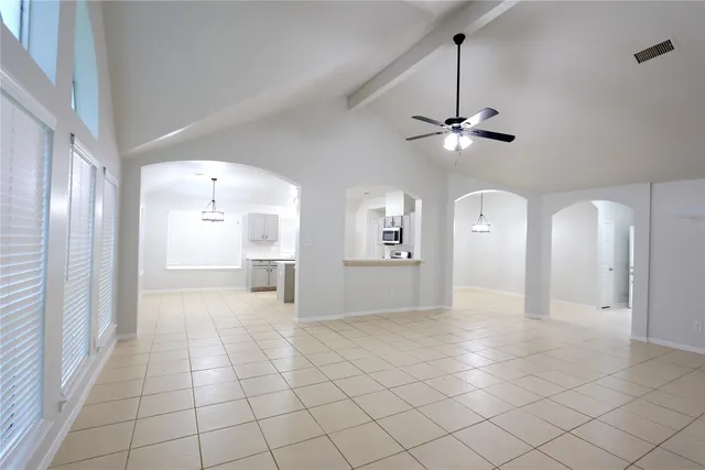a view of a livingroom with a chandelier fan and windows