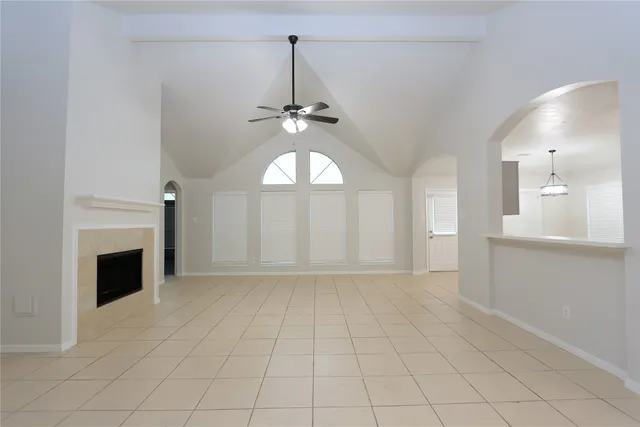 a view of a livingroom with a fireplace a chandelier and windows
