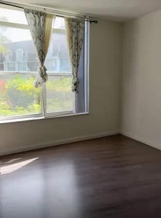 a view of a room with wooden floor and a window