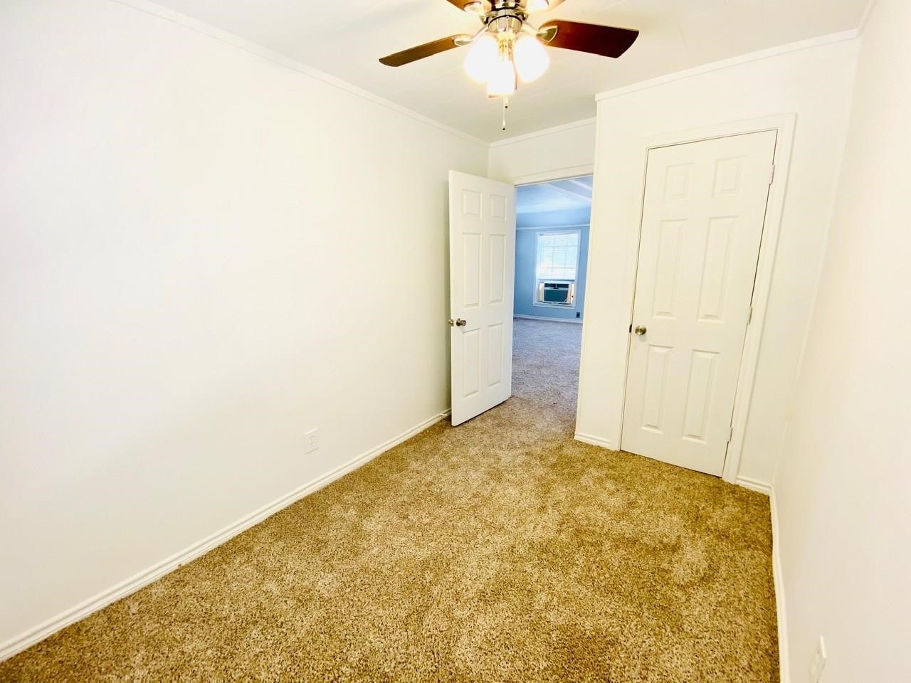4730 Oleander Street Bacliff, TX 77518 - Photo 13 of 18 an empty room with a ceiling fan and carpet